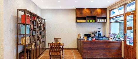 A kitchen with wooden cabinets, a dining table with chairs, and a coffee machine.