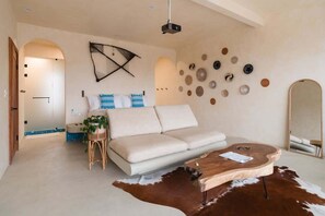 A modern living room with a sofa, a wooden coffee table, and a cowhide rug.