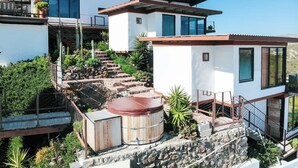 A modern two-story house with a stone staircase leading to a wooden deck. - Native Residence Casa 6 (Playas de Rosarito)