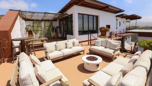 A rooftop terrace with white sofas, a coffee table, and potted plants. - Native Residence Casa 6 (Playas de Rosarito)