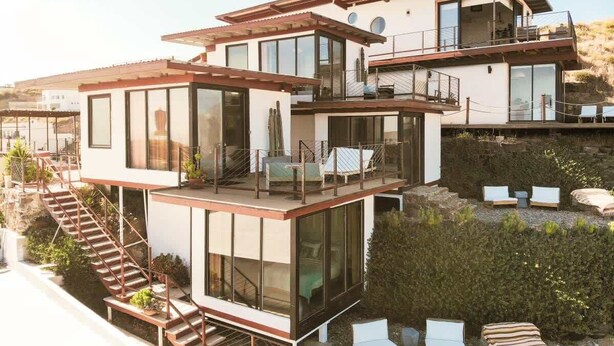 A modern multi-story house with a balcony, outdoor seating, and a staircase. - Native Residence Casa 6 (Playas de Rosarito)