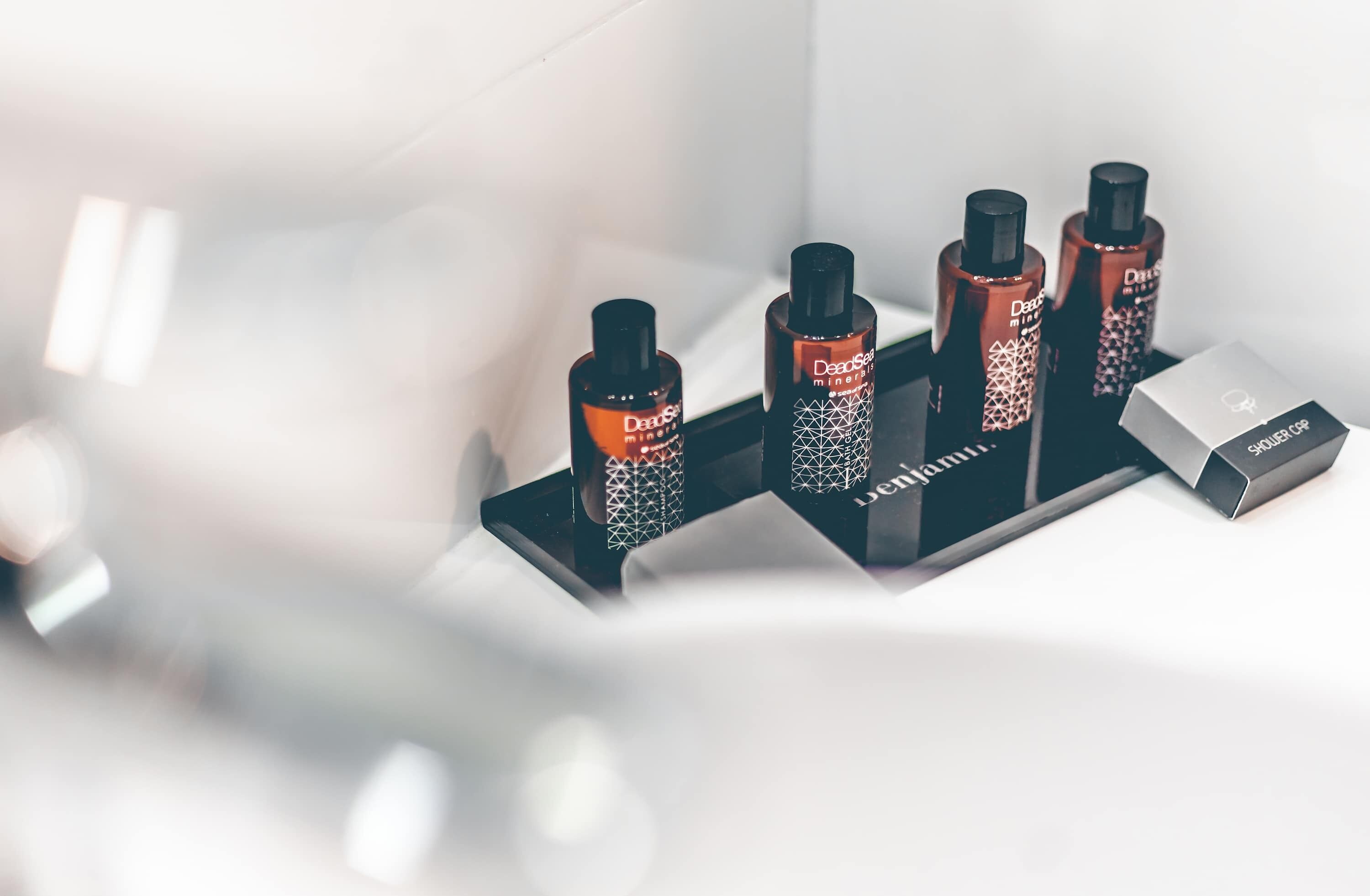 Een set DejaBlue minerale haarproducten op een zwarte standaard, met een zilveren doos met de tekst 'SHOWER GRIP' ernaast.