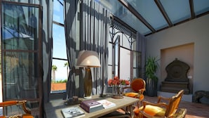 A sunlit room with a large window, a table with books, a lamp, and a chair. - Villa Kalisa in Sorrento (Sorrento)