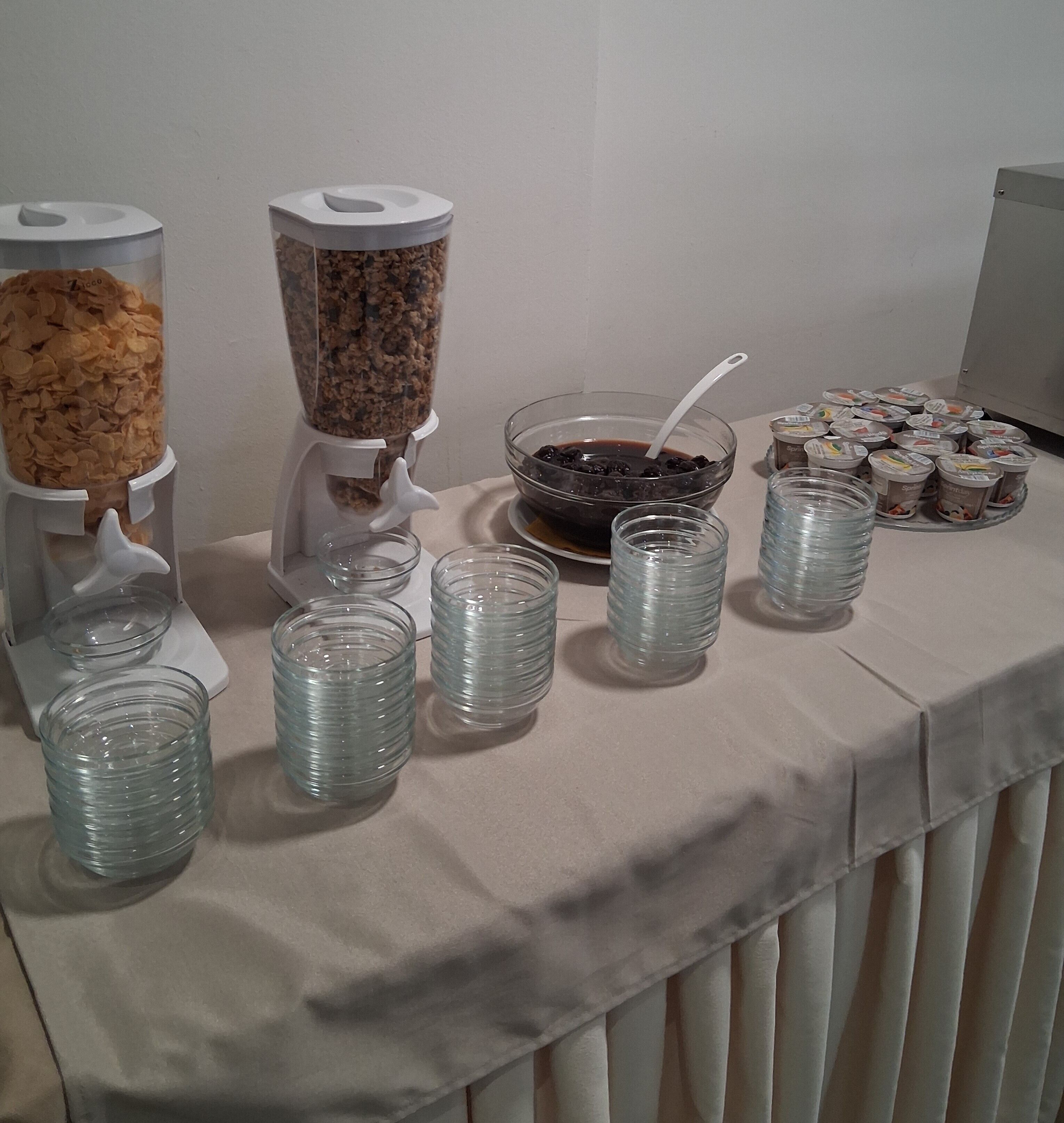Una mesa de buffet con diversos alimentos y dispensadores de bebidas.