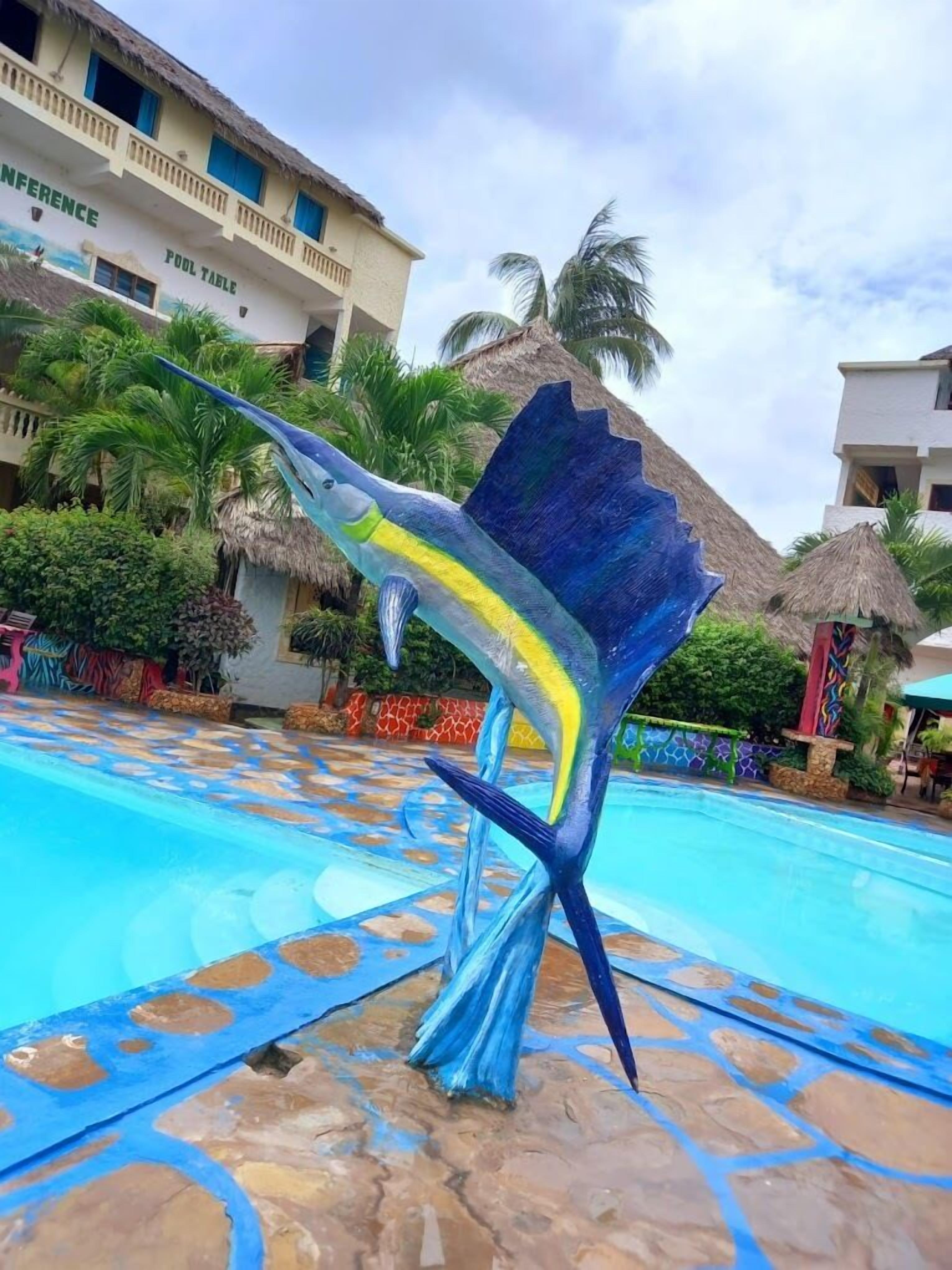 Una piscina con una escultura decorativa de un pez.