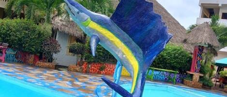 Una piscina con una escultura decorativa de un pez.
