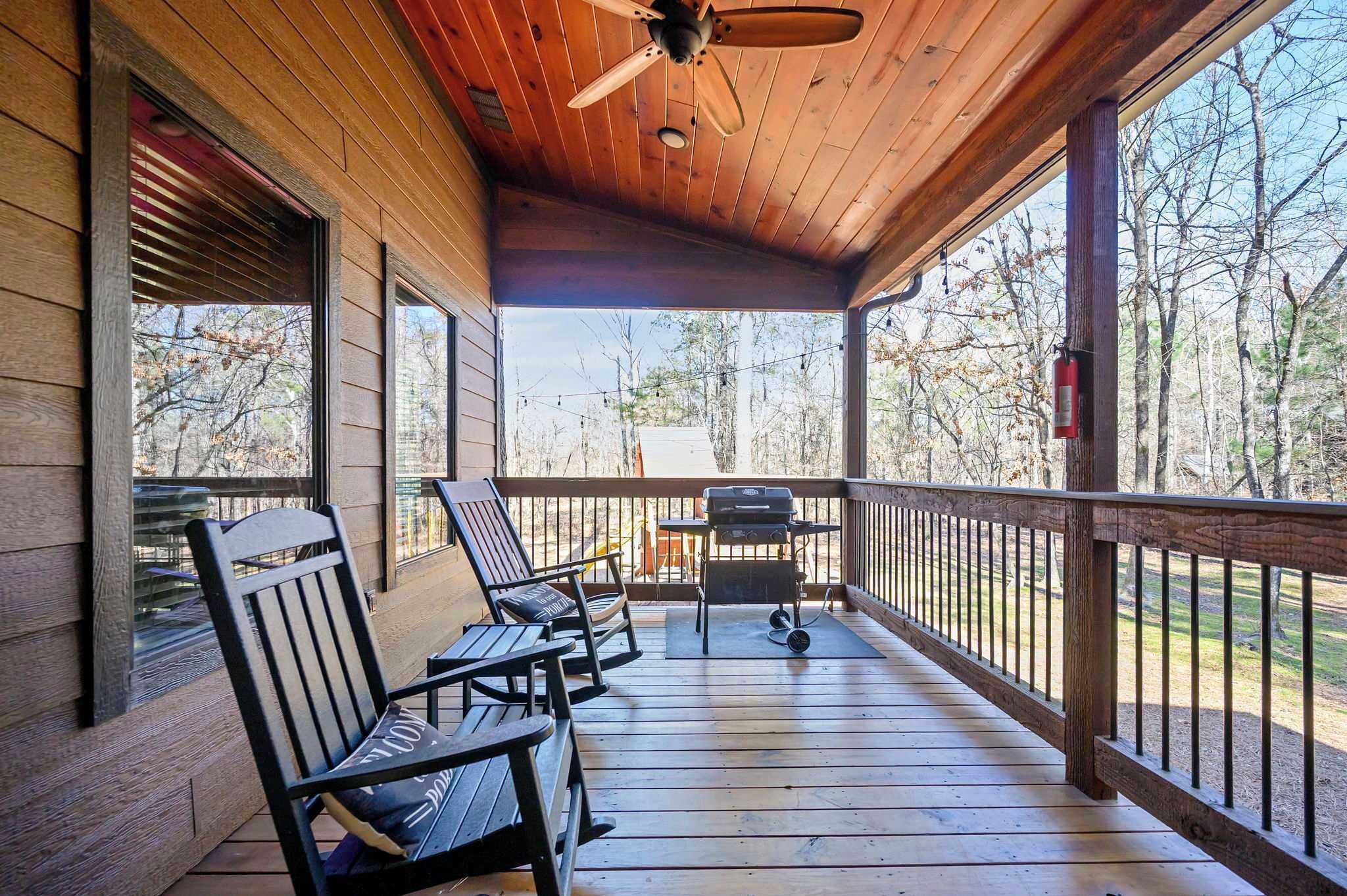 A wooden deck with outdoor seating and a grill.