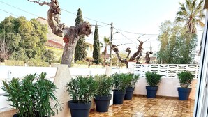 A tiled patio with potted plants and a decorative tree sculpture. - Fully equipped pool house Canet plage perfect for a nice vacation (Canet-en-Roussillon)