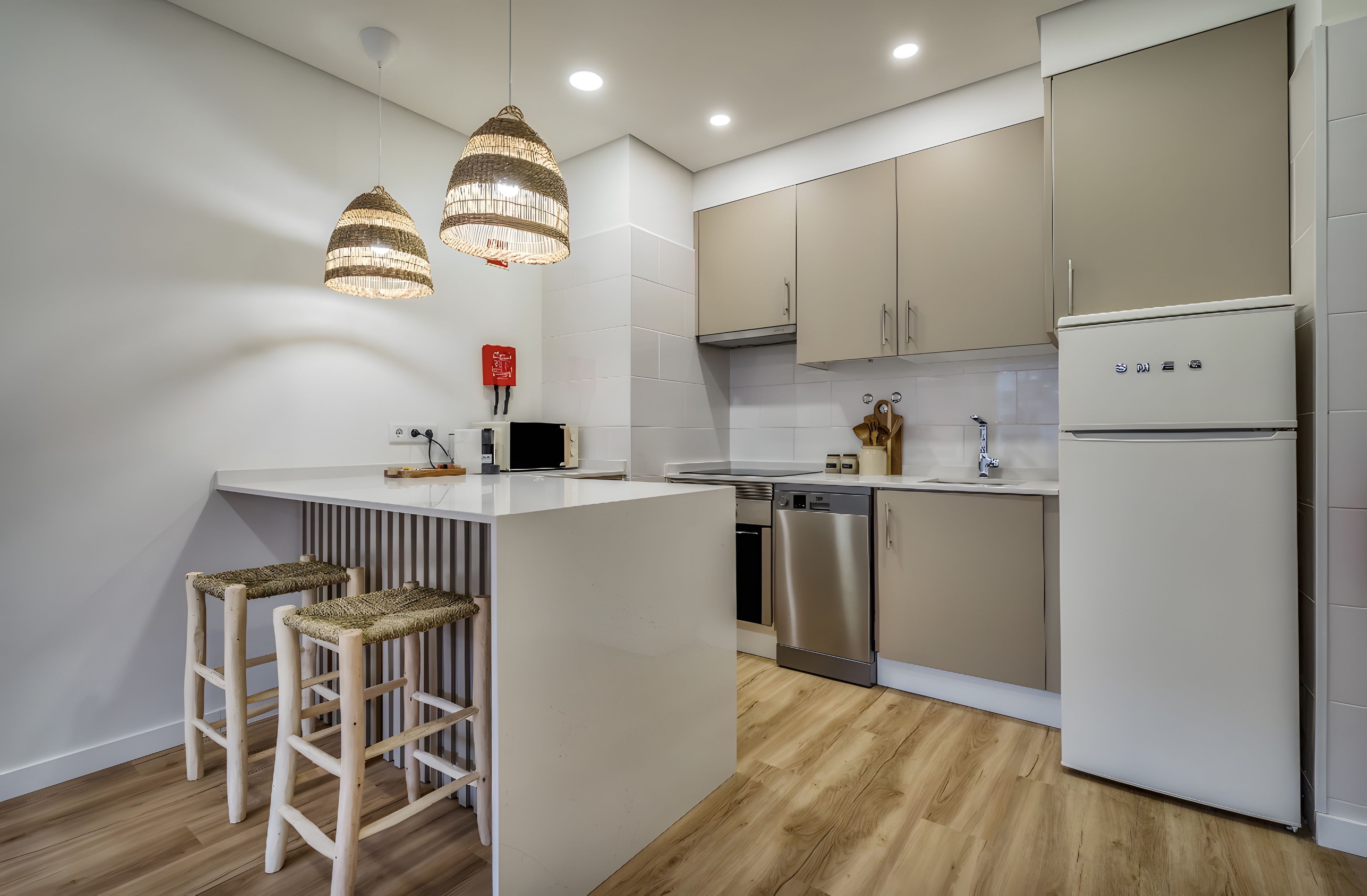 Una cocina moderna con una isla central, electrodomésticos de acero inoxidable y piso de madera.