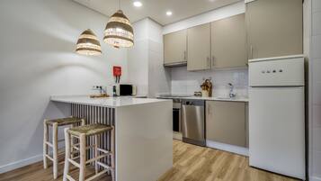 Una cocina moderna con una isla central, electrodomésticos de acero inoxidable y piso de madera.