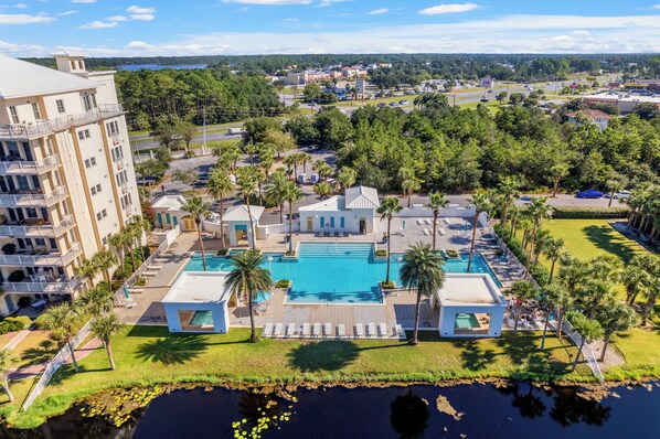 Un resort con una piscina grande, varias edificaciones y vistas del entorno.