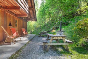 Eine Holzhütte mit Sitzgelegenheit im Freien und einem Picknicktisch.