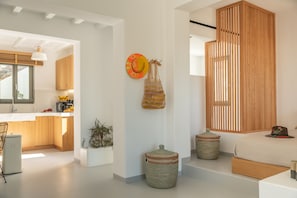 Ein modernes Interieur mit Küche, Essbereich und einem Schlafzimmer mit großem Fenster.