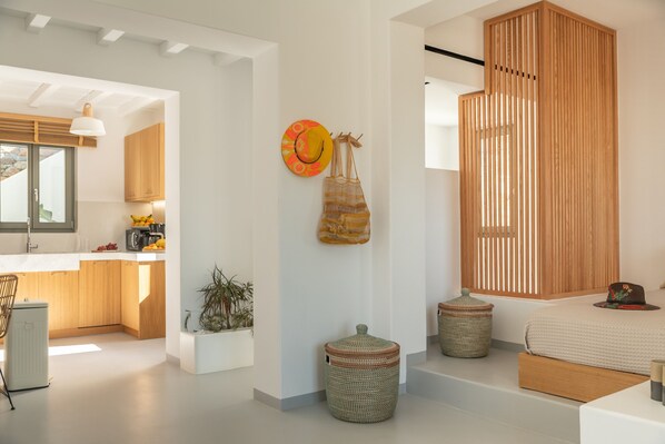 Un intérieur moderne comprenant une cuisine, un coin repas et une chambre avec une grande fenêtre.