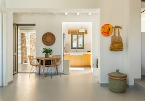 Eine moderne Küche mit Steinwand, Holzschränken und einem Essbereich mit Tisch und Stühlen.