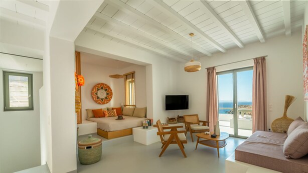 Una sala de estar moderna con sofá, televisión y balcón con vistas.