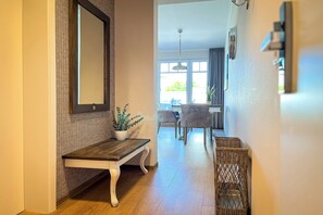 A hallway with a wooden bench, a potted plant, and wicker baskets. - Baltischer Hof apartment 53 (Ostseebad Boltenhagen)