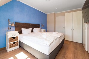 Een hotelkamer met een bed, nachtkastjes, een kledingkast en een televisie.