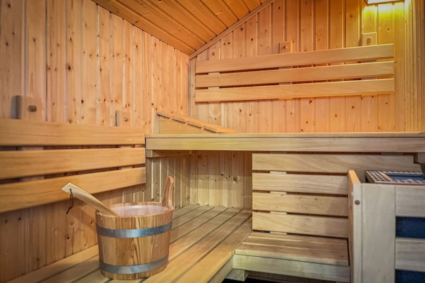 Eine Holzsauna mit Bänken und einem Holzeimer.