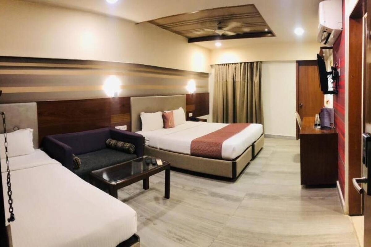 Una habitación de hotel con cama, sofá, escritorio y armario.
