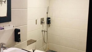 A small bathroom with a white sink, a toilet, and a shower. - Astra Hotel and Suites Kaadubesanahalli (Kadubeesanahalli)