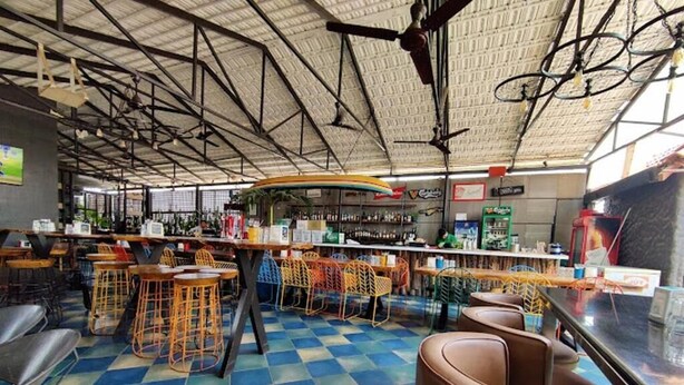 A bar area with stools, a counter, and a checkered floor. - Astra Hotel and Suites Kaadubesanahalli (Kadubeesanahalli)
