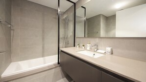 Une salle de bain moderne avec une baignoire, un lavabo et un grand miroir.
