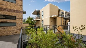 A modern apartment building with balconies, a stone facade, and a courtyard with plants. - Beachfront Gem in Capel Sound (Capel Sound)
