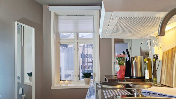 A kitchen with a window, a sink, a stove, and various kitchen utensils. - Cozy, Central Studio by the Bus Station (Bergen)