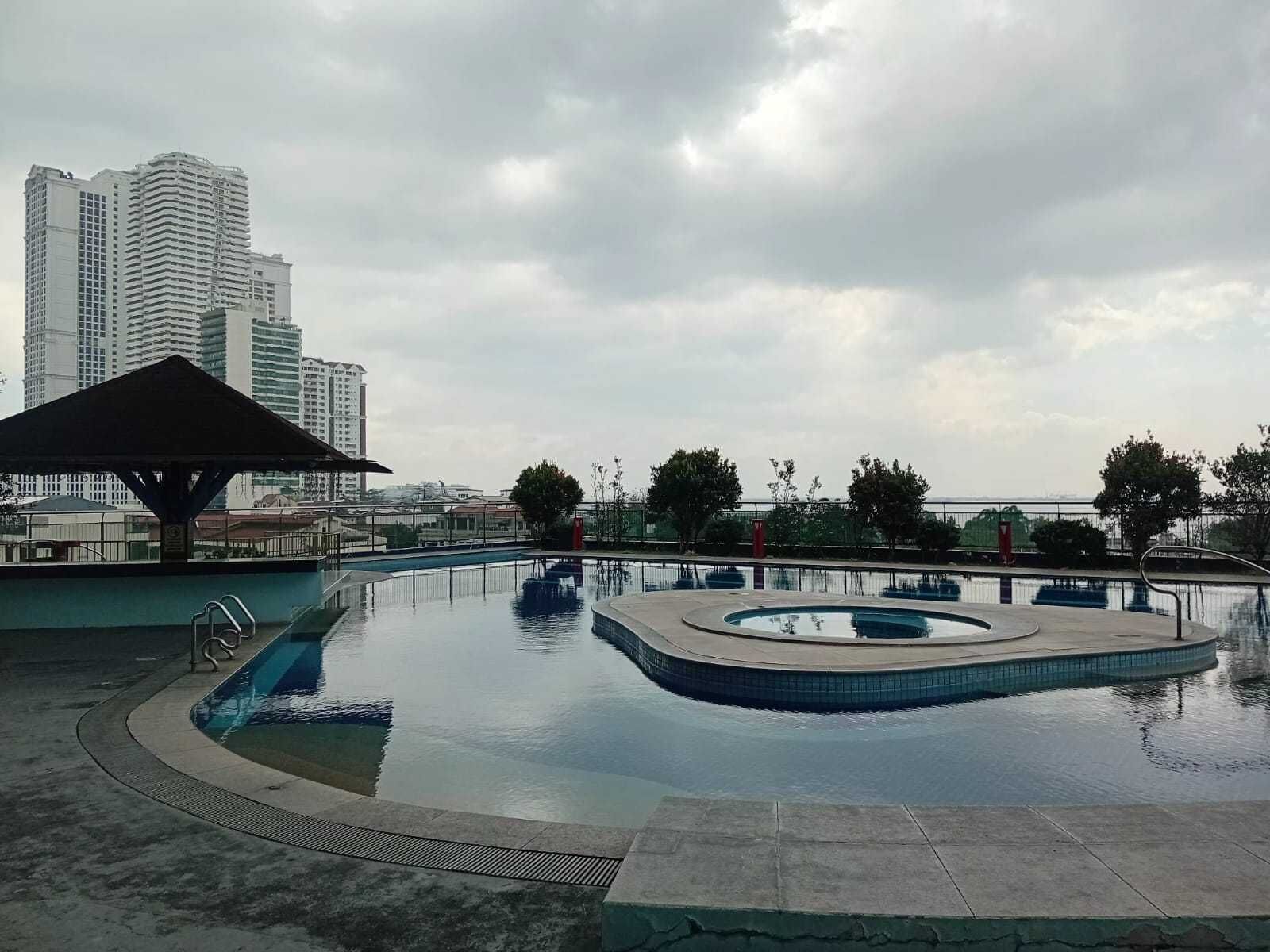 A swimming pool with a pavilion and a view of tall buildings in the background.