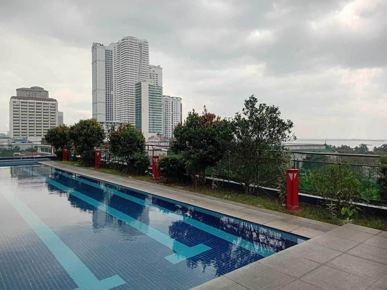 A swimming pool with a cityscape in the background.