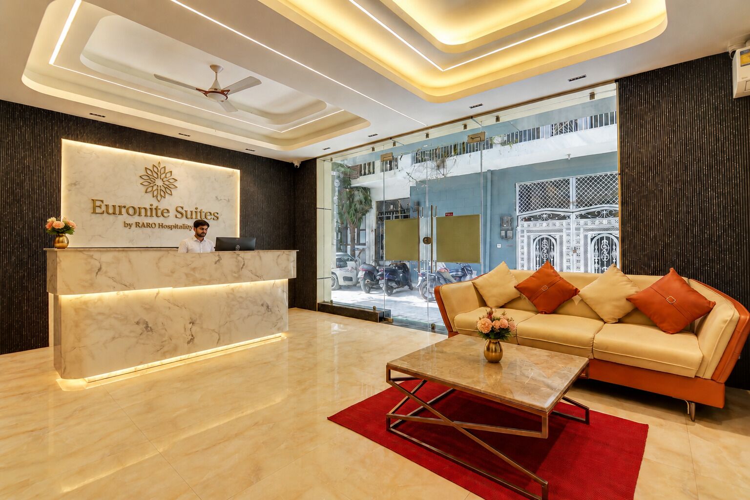 A hotel reception area with a marble reception desk, a sofa, and a coffee table.