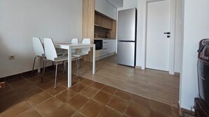 Eine moderne Küche mit Esstisch und Stühlen, einem Kühlschrank und Holzschränken.