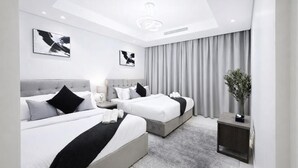 A modern hotel room with two beds, a grey carpet, and a large window with grey curtains. - Lucky Getaways (Dubai)