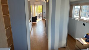 Un dormitorio moderno con una cama grande, una mesita de noche y un ventanal con vistas a edificios.