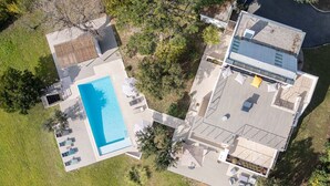 An aerial view of a modern house with a swimming pool, a patio area, and a covered outdoor space. - Villa d’exception, Vue mer et Rooftop Super Cannes (Vallauris)