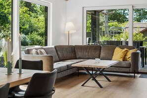 A modern living room with a sofa, a coffee table, and a lamp.