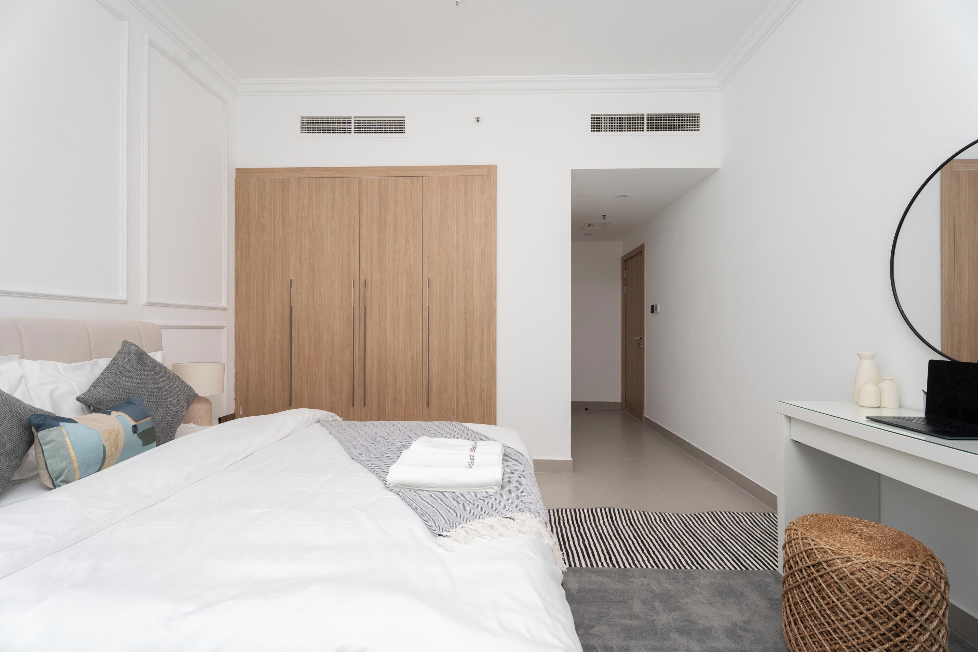 Une chambre d’hôtel moderne équipée d’un lit, d’un bureau, d’une chaise et d’une armoire.