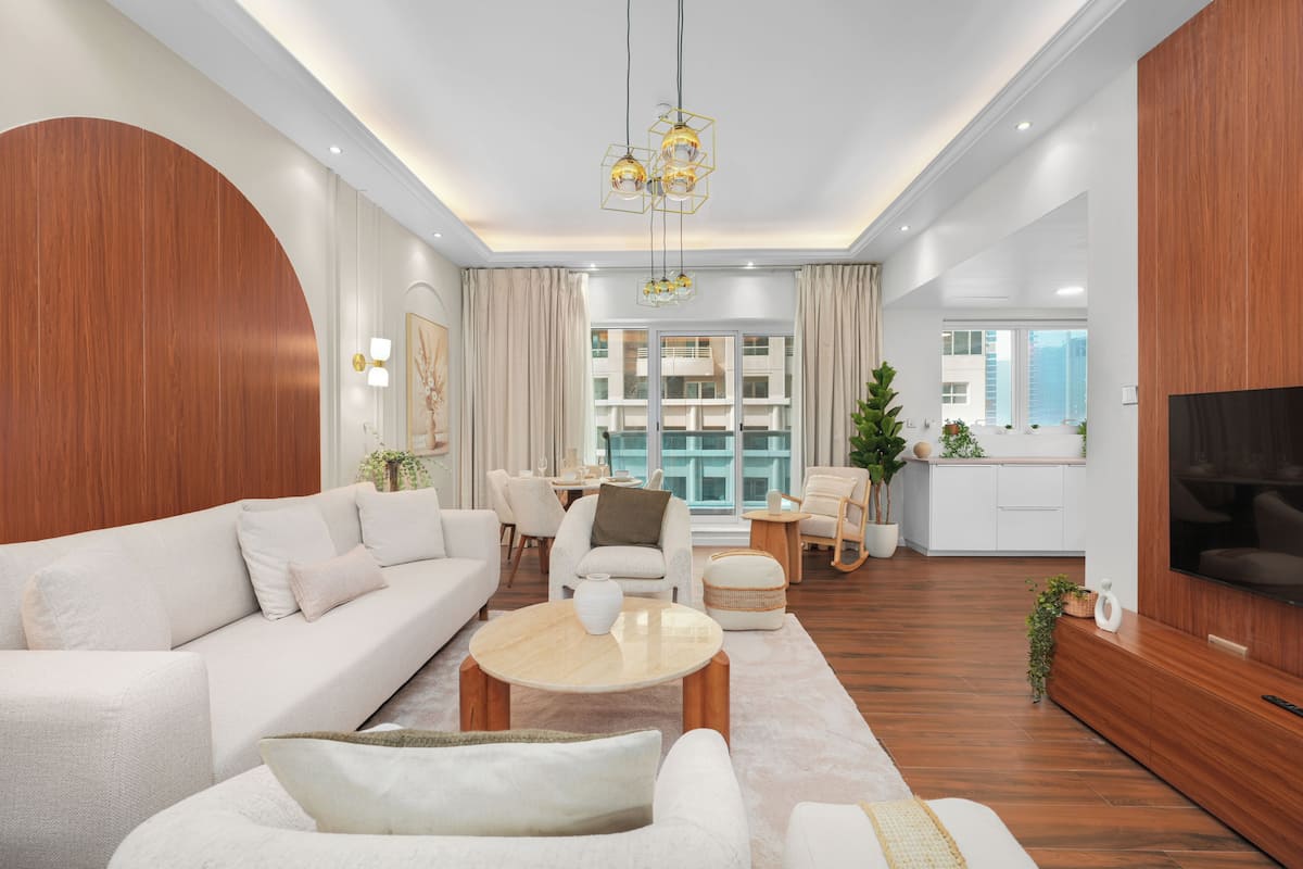 A modern living room with a sofa, chairs, a coffee table, and a TV.