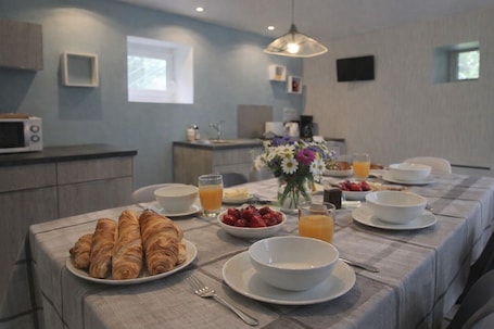 A breakfast setup with croissants, strawberries, and orange juice on a table with a checkered tablecloth.. Bed and Breakfast 'Chambre Familiale' with Private Terrace, Shared Garden and Wi-Fi