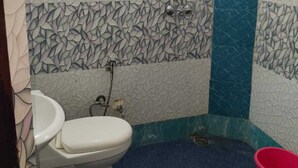 A bathroom with a toilet, a shower, and a sink. - HOTEL DYNA INN (Gwalior)