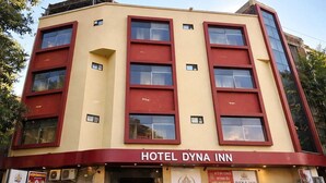 A hotel with a yellow facade and red accents, featuring multiple windows and a prominent entrance. - HOTEL DYNA INN (Gwalior)