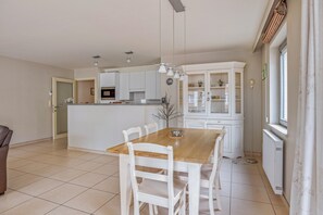 Una cocina amplia con armarios blancos, una mesa de comedor de madera y una pequeña isla.