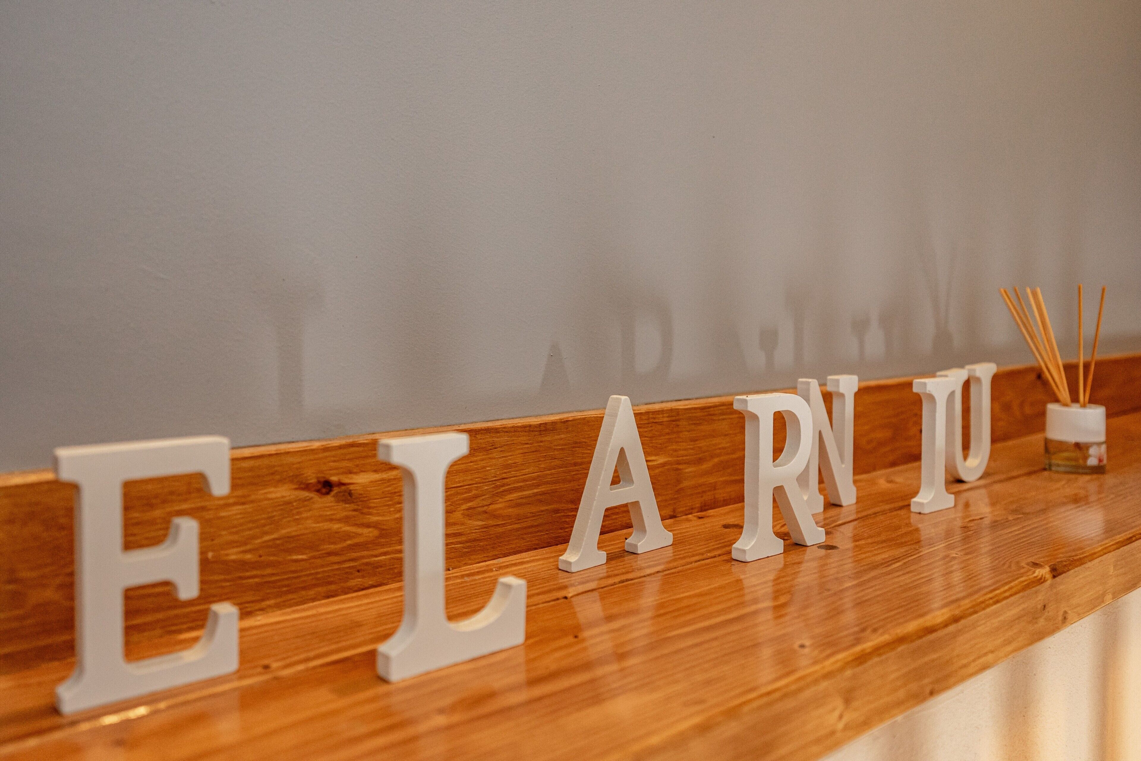 Lletres de fusta que escriuen 'ELARNU' sobre una superfície de fusta.