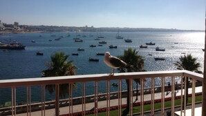 A balcony with a railing overlooking a marina with boats and a distant cityscape. - Apartment 'Cascais Bay Terrace V' with Sea View, Wi-Fi and Air Conditioning (Cascais)