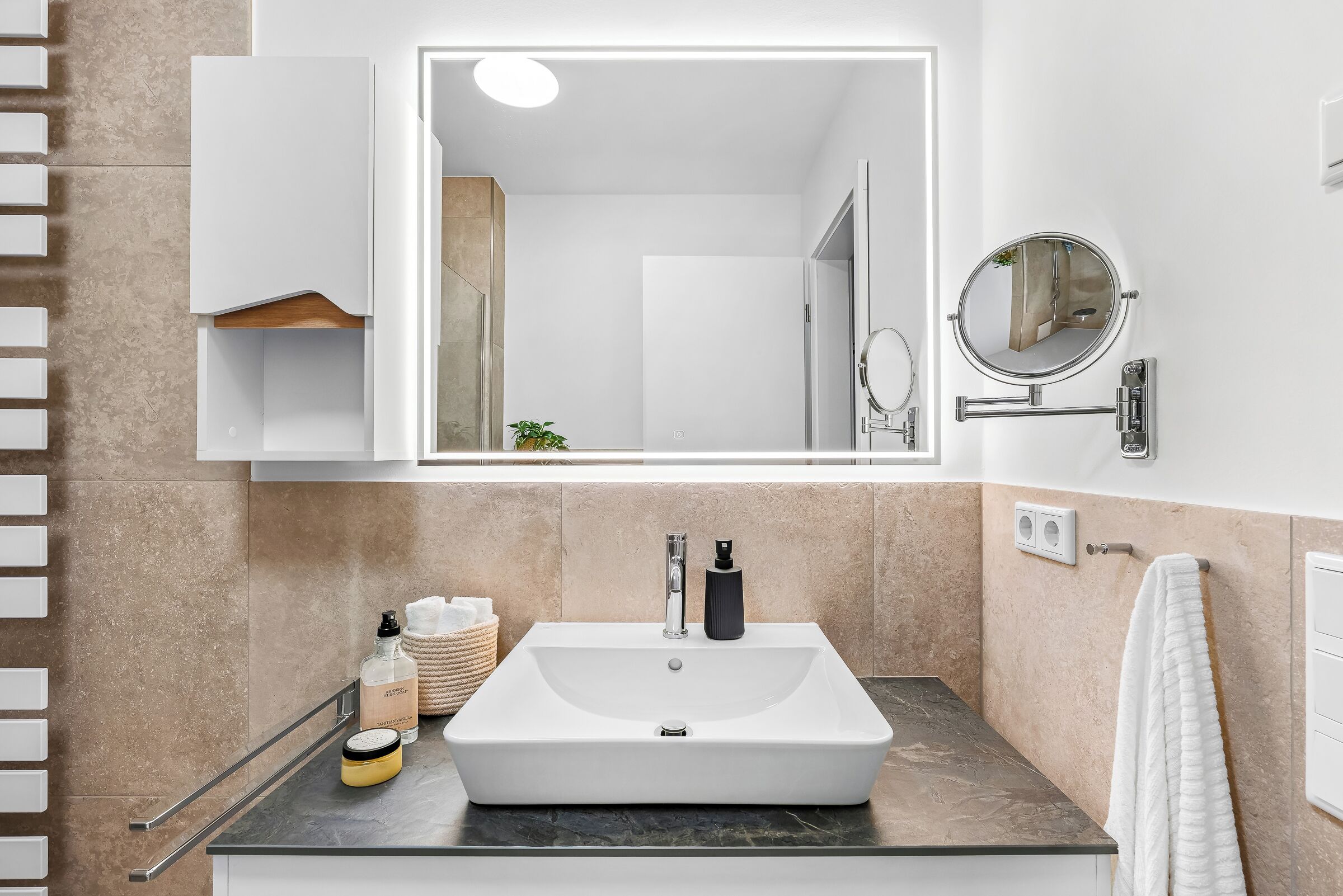 Un bagno moderno con un ampio specchio, un lavabo rettangolare e un portasciugamani.