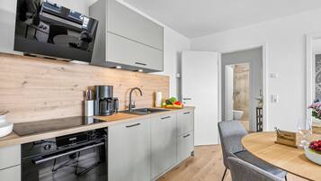 Eine moderne Küche mit Geschirrspüler von Bosch, einer Kaffeemaschine und einem Spülbecken.