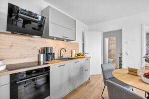 Une cuisine moderne équipée d’un lave-vaisselle Bosch, d’une machine à café et d’un évier.