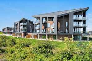 A modern multi-story residential building with balconies and large windows. - The View B14 Nordseeperle – Balcony, sea view, shared sauna (Dagebüll)