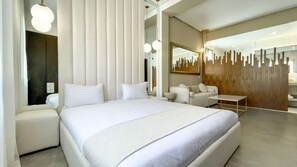 A modern hotel room with a large bed, a seating area with a sofa and armchairs, a wooden accent wall, and a large mirror. - Magnificent Villa Asma heated pool (Marrakech)